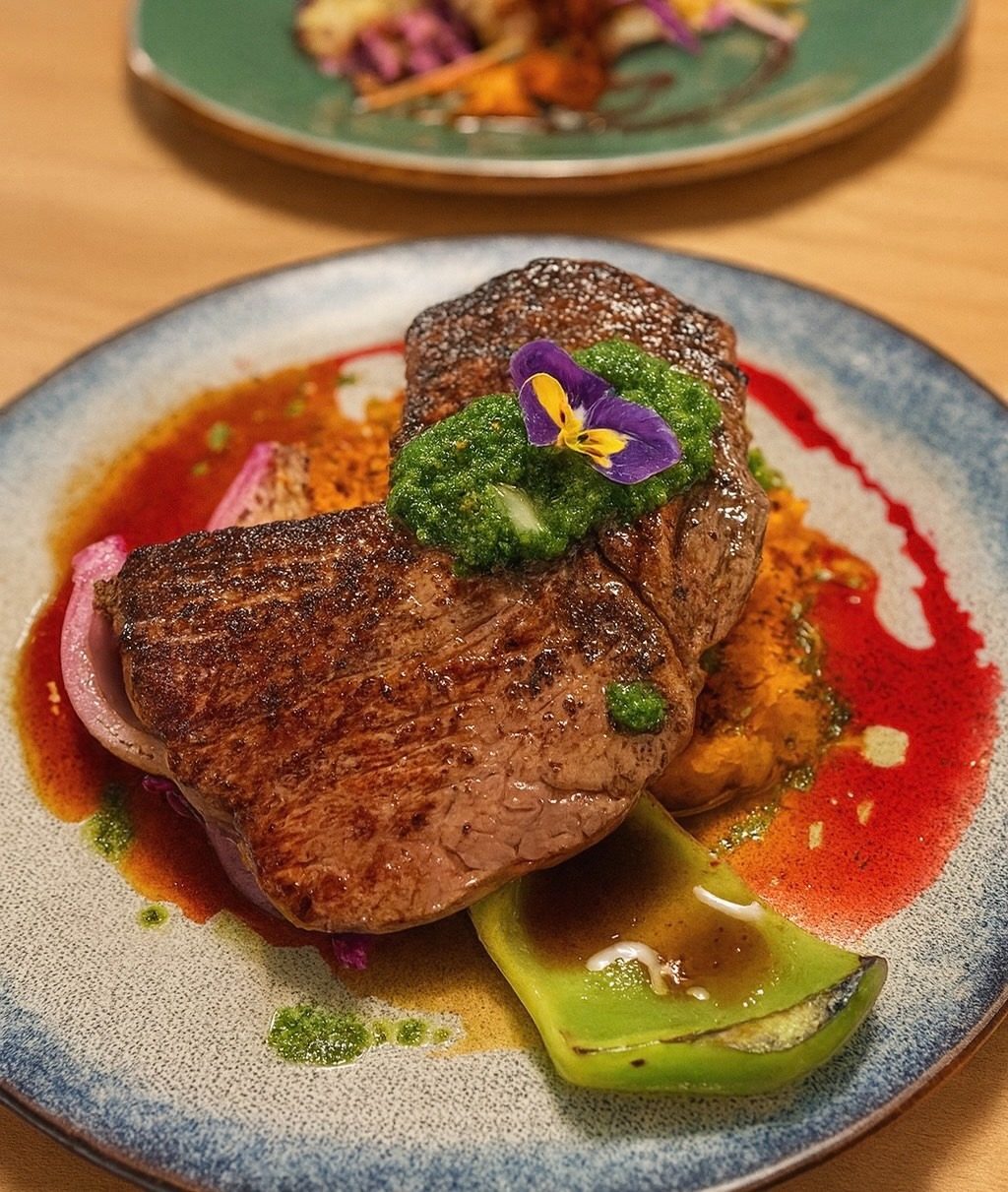 Medium-rare venison plated with polenta and tomatoes